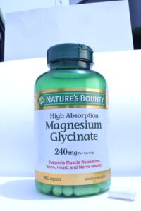 A bottle of magnesium glycinate capsules on a plain background