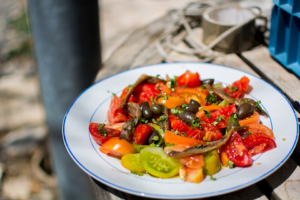 Mediterranean diet ingredients: olive oil, fish, legumes, grains, vegetables, and herbs on a table.”