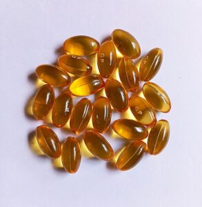 “Clear dish of garlic supplement capsules, representing aged garlic extract.”