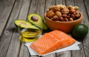 “Salmon fillets, avocado, walnuts, and leafy greens arranged together as anti-inflammatory foods rich in omega-3”