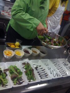 "Chef preparing a fresh green salad in a kitchen"