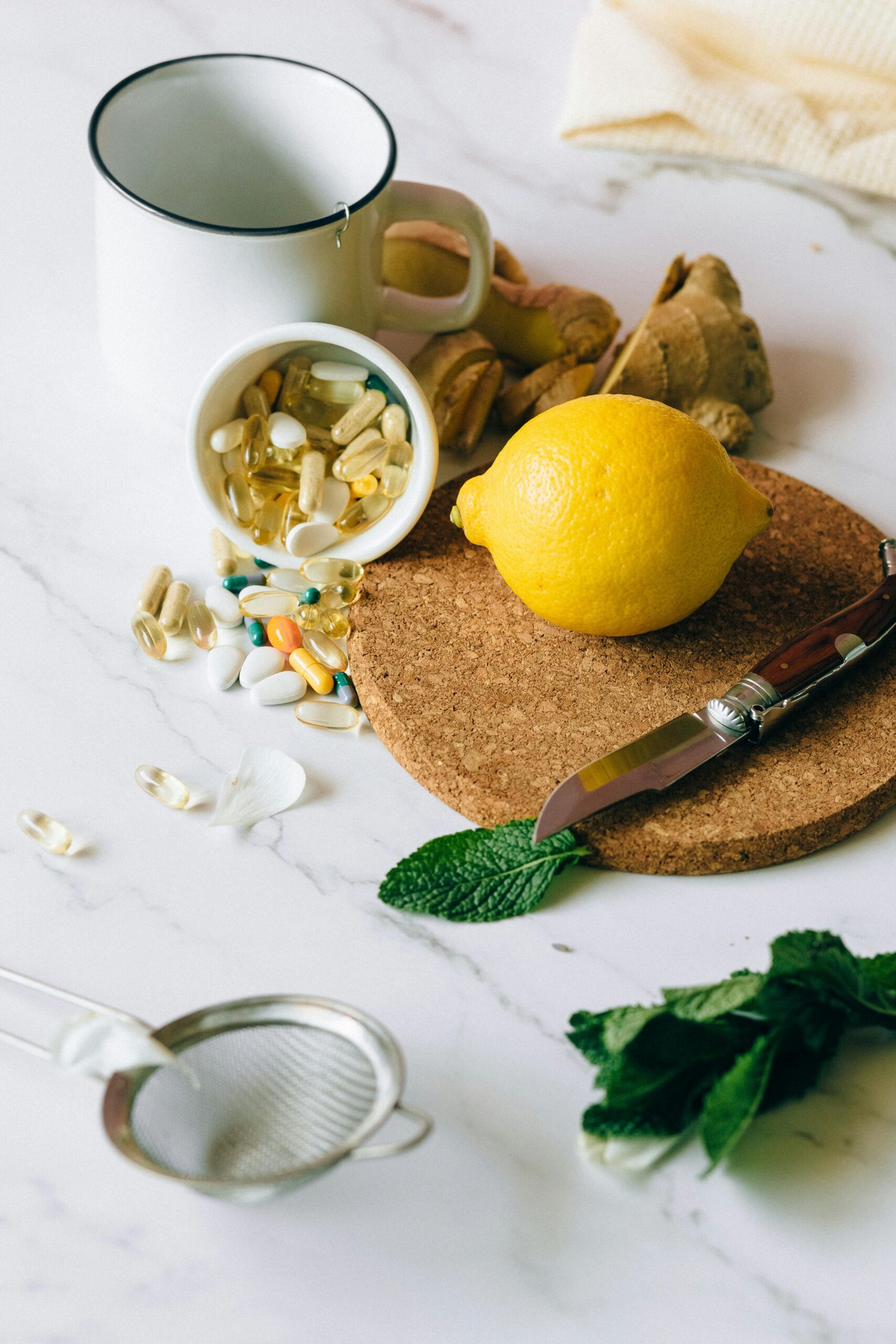 “Top view flat lay of herbal supplements, pills and natural medicine ingredients on a light marble surface.”