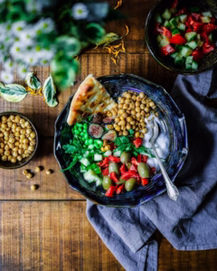 “Assorted nuts, seeds, and oil in small bowls on a wooden table representing dietary fats”
