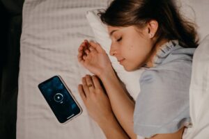 women sleeping next to her phone